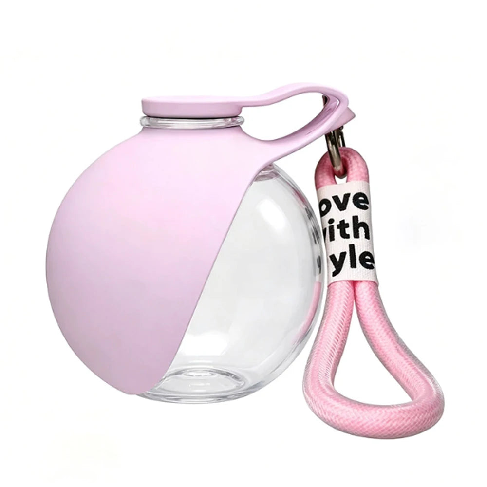 Light pink portable pet water bottle with clear lower section and carry strap