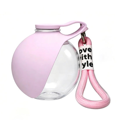 Light pink portable pet water bottle with clear lower section and carry strap